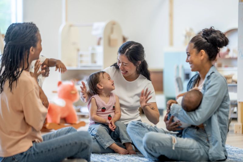 A joyful scene of mothers and children enjoying quality time together indoors, highlighting love and fellowship.