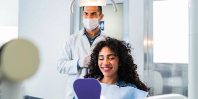 Happy woman checking her smile at the dentist.