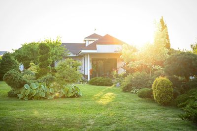 Elegant suburban house with stone pillars and a well-maintained garden.