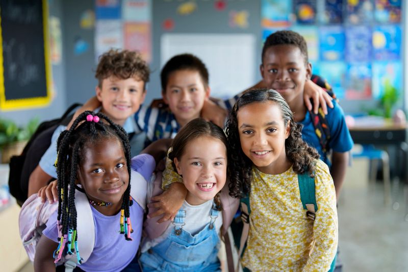 A vibrant group of diverse school children smiling and enjoying their time learning in a classroom environment, highlighting friendship, education, and inclusion.