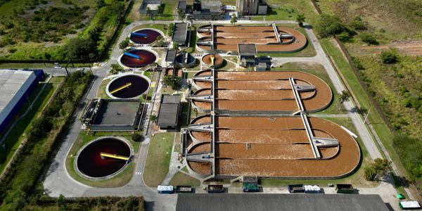 Aerial view of a wastewater treatment plant with multiple sedimentation tanks.