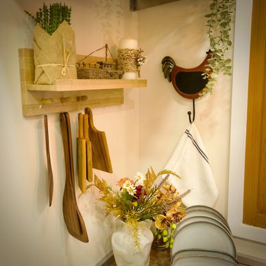 Cozy kitchen corner with wooden utensils, flowers, and decorative items.