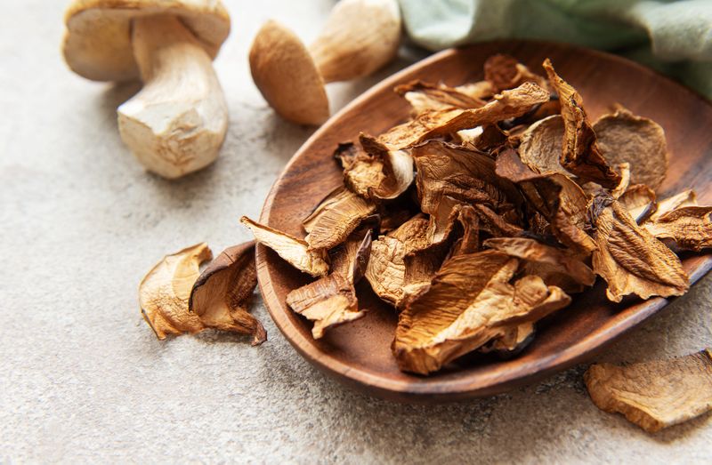 Wooden bowl brimming with dried porcini mushrooms, showcasing rich earthy tones and delicate textures