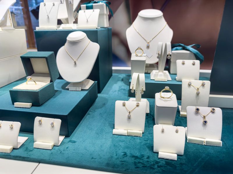 Showcase with luxury golden diamond necklaces, bracelets and earrings in a jewellery shop. Shopping concept