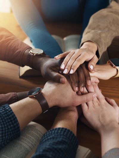 Diverse hands stacked together showing unity.