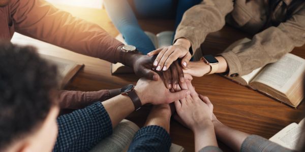 Group with hands stacked showing unity and teamwork.