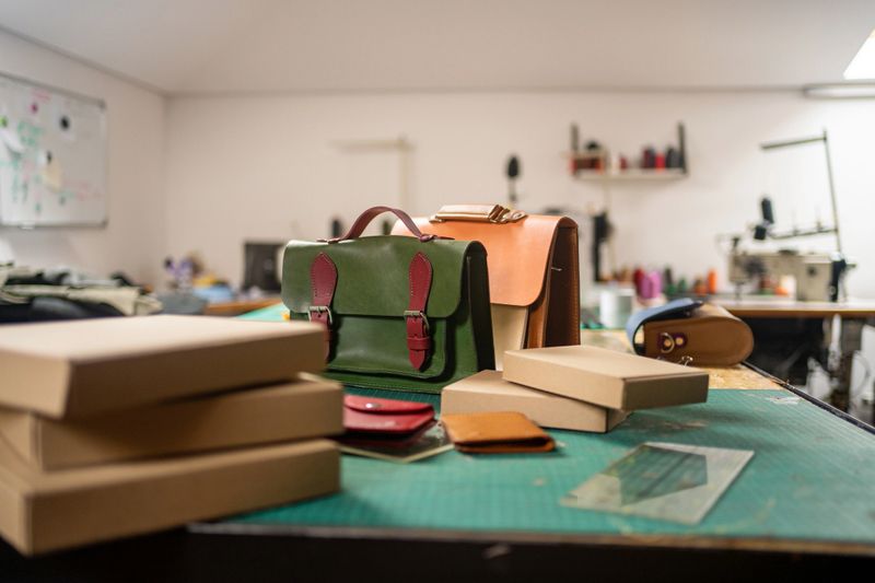 Handmade leather bags and wallets in workshop ready for packing and delivering