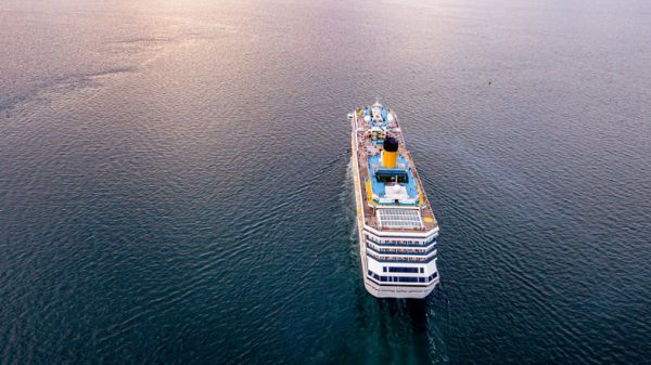 A cruise ship sailing on calm waters during sunset.
