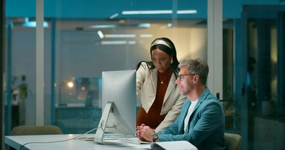 Two business owners reviewing a new website design on a computer at Online Biz Boost