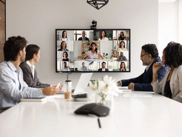 People attending a video conference in a meeting room.