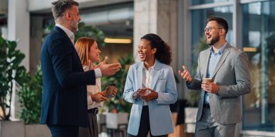 Four professionals engaged in a lively conversation at a modern office.