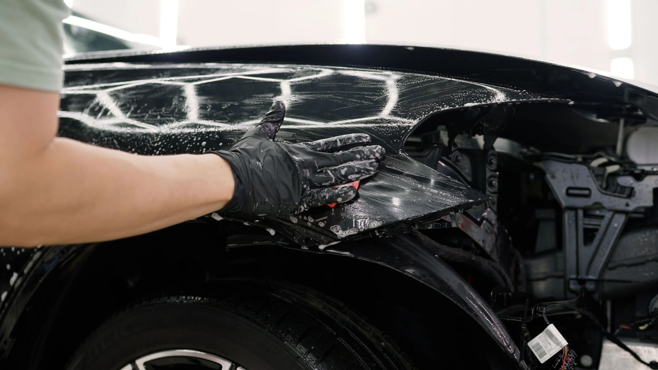 Exterior auto detailing process in Shelby Ohio, showing a black car getting washed
