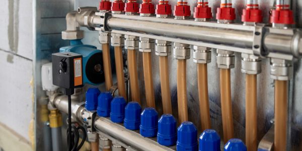 Close-up of plumbing system with pipes and valves in a mechanical room.
