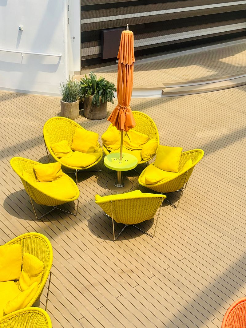 Exterior details of a modern cruise ship. Large white hull, multiple decks with balconies, and lifeboats visible.