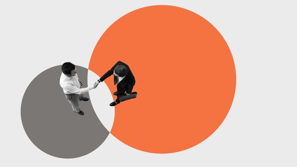 Two men shaking hands with colorful circles background.