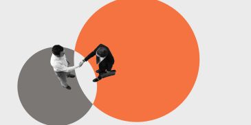 Two people shaking hands within overlapping circles.