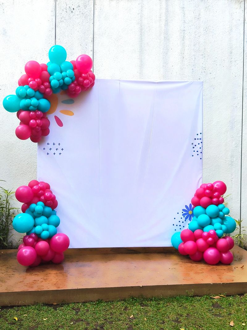 A cheerful and vibrant balloon arch and backdrop provide a simple yet elegant setting for various celebration events, with ample copy space.
