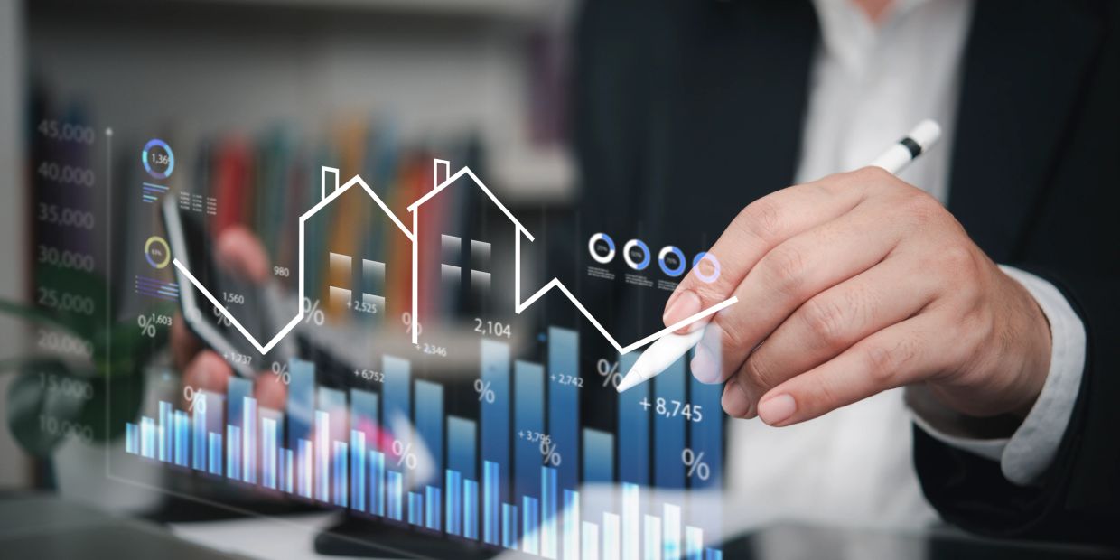 Businessman analyzing real estate market trends with digital charts and graphs.