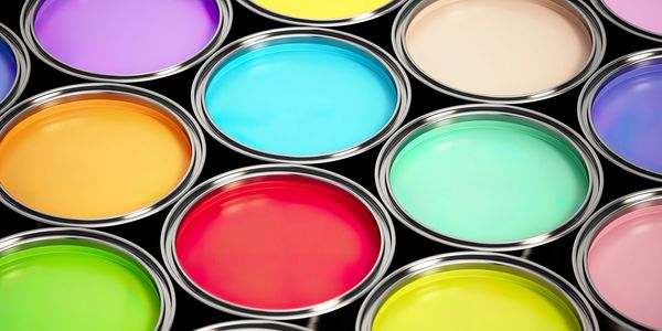 Open paint cans filled with various vibrant colors arranged closely together.