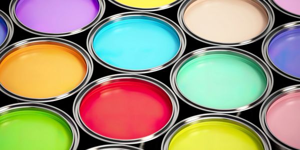 Open paint cans filled with various vibrant colors arranged closely together.