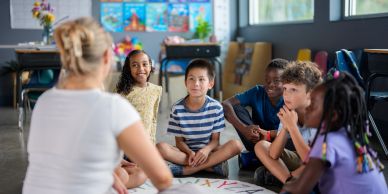 Teacher engaging a diverse group of children in a classroom activity.