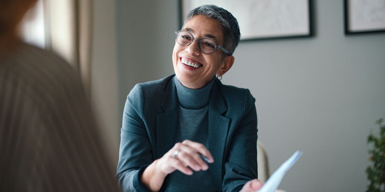 Smiling professional woman in glasses during a meeting.