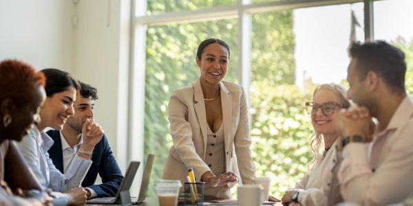 Businesswoman leading a team meeting with enthusiasm.