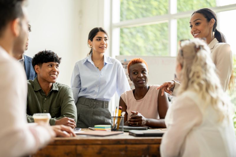 A team of professionals from diverse backgrounds working together in a well-lit office space.