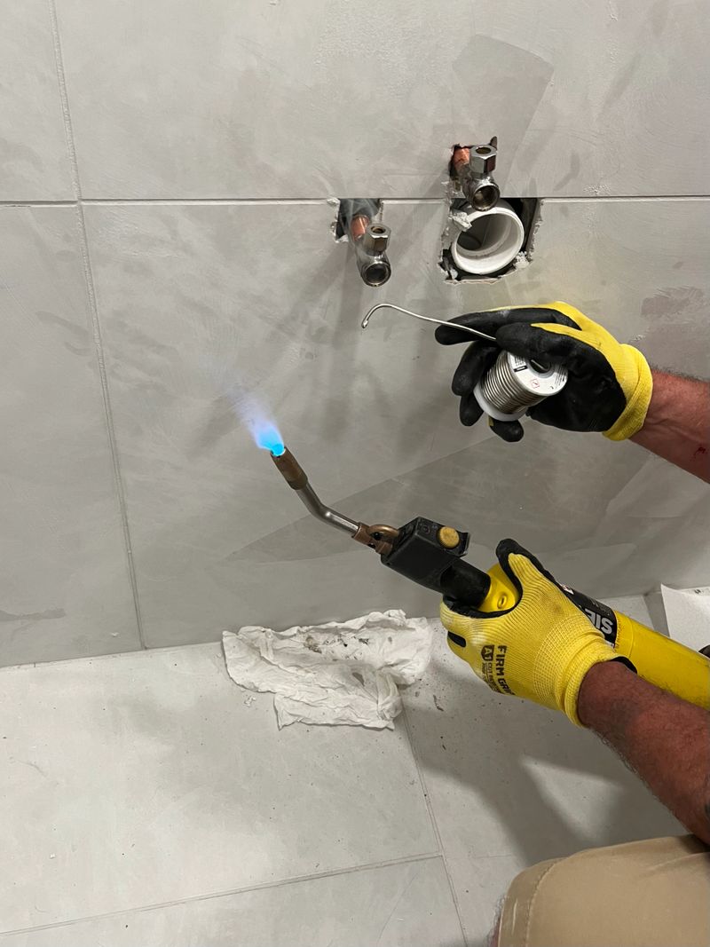 A man soldering pipes for a sink.