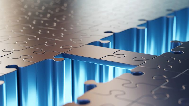 Puzzle pieces forming a seamless connection illuminated by blue light, symbolizing problem-solving and partnership.