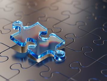 A transparent puzzle piece on a dark puzzle surface.