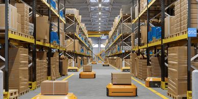 Autonomous robots moving packages in a warehouse aisle.