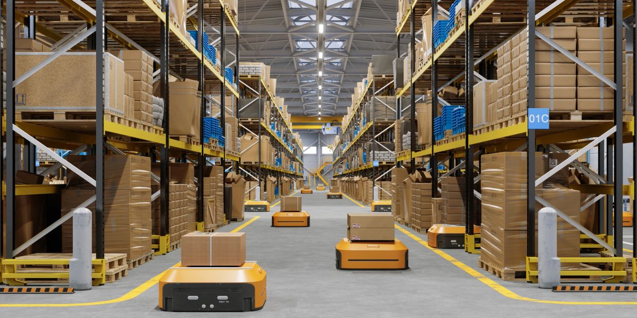 Automated robots carrying boxes in a large warehouse.