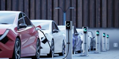 A row of electric cars charging at a modern charging station.