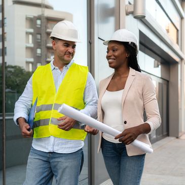 Two construction professionals discussing plans outside a modern building.