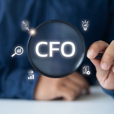 Magnifying glass highlighting CFO with financial icons.
