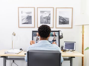 Person participating in a video conference at a desk.