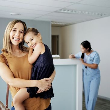 Mother holding her daughter in a clinic.