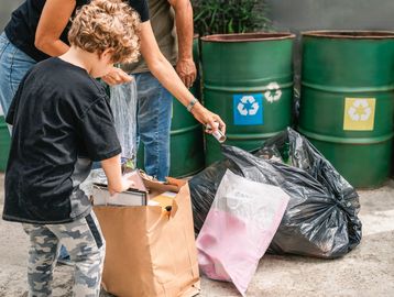 People sorting and recycling waste outdoors.