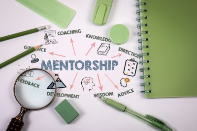 Conceptual mentorship diagram surrounded by green stationery items.