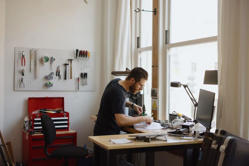 Skilled technician working on electronics repair in a modern, organized workshop, demonstrating expertise and precision