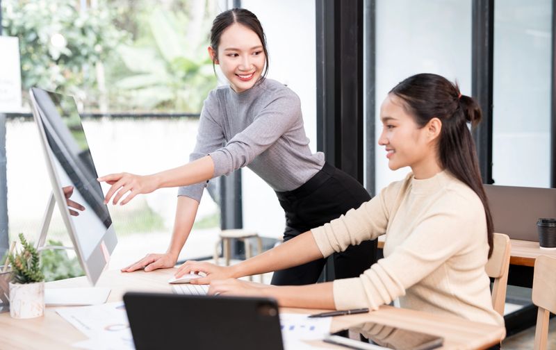Working together on project. Two young business colleagues working on computer