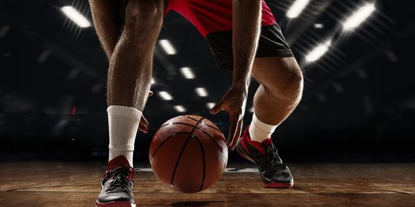Player dribbling a basketball on court.