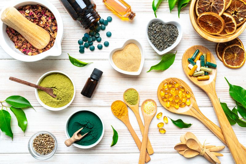 White table filled with nutritional supplements and natural vitamins. Healthy eating and dieting, healthcare or alternative medicine. Spirulina pills, Moringa powder and Omega-3 capsules, Magnesium and Calcium