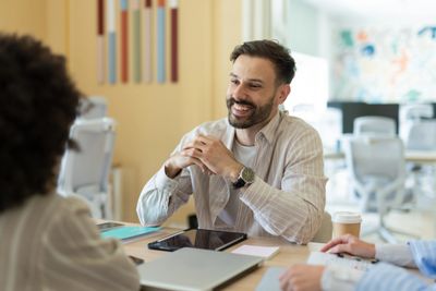 Smiling man engaged in a friendly conversation at a meeting.
