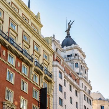 Detailed urban architecture with a sculpture atop a dome.