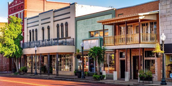 Historic downtown street with vintage brick buildings and clear blue sky.