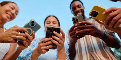 Group of people looking at their smartphones and smiling.