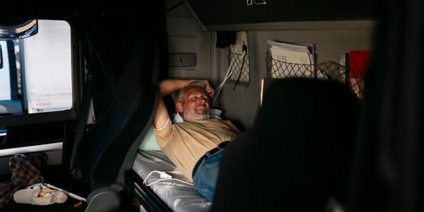 A man resting comfortably inside a truck cabin.