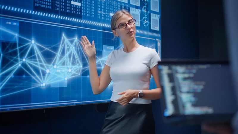 AI developers discussing and brainstorming during a collaborative meeting in a high-tech office. The scene highlights teamwork, data visualization on digital screens, and innovation in artificial intelligence development, reflecting a modern environment focused on building cutting-edge AI solutions.